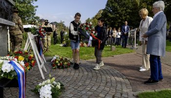 Kinderen van de adoptieklas van de Odaschool helpen met bloemen leggen
